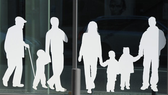 Silhouetten von Menschen in verschiedenem Alter sind auf Fensterscheiben aufgeklebt. © picture alliance/dpa Foto: Jens Kalaene