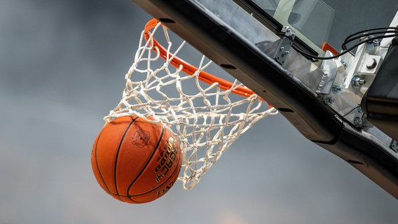 Ein Basketball fliegt durch einen Korb. © picture alliance/Andreas Gora Foto: Andreas Gora