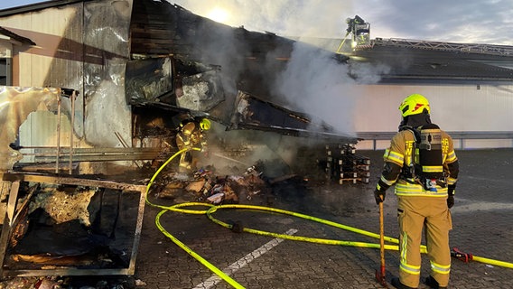Ein Supermarkt ist nach einem Brand in Westhagen stark beschädigt. Im Vordergrund steht ein Feuerwehrmann. © Feuerwehr Wolfsburg Foto: Feuerwehr Wolfsburg