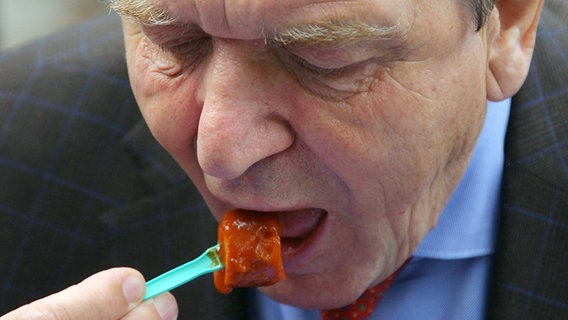 Altkanzler Gerhard Schröder isst eine Currywurst. © dpa-Bildfunk 