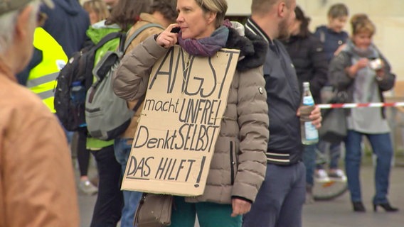 Eine Frau trägt ein Schild mit der Aufschrift: "Angst macht unfrei. Denkt selbst. Das hilft." © Hannover Reporter 