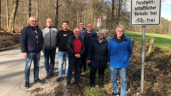 Einwohner und Einwohnerin aus Derental, Neuhaus und Umgebung posieren für ein Foto vor einem gesperrten Forstweg. © NDR Foto: Tullio Fancesco