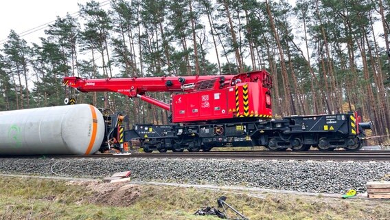 Ein rotes Fahrzeug zum Anheben des Kesselwagens auf den Schienen. © NDR Foto: Michael Brandt