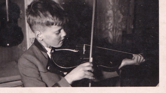 Auf einer Schwarz-Weiß-Fotografie ist Eckhard Schimpf als kleiner Junge beim Geigespielen zu sehen. © Eckhard Schimpf 