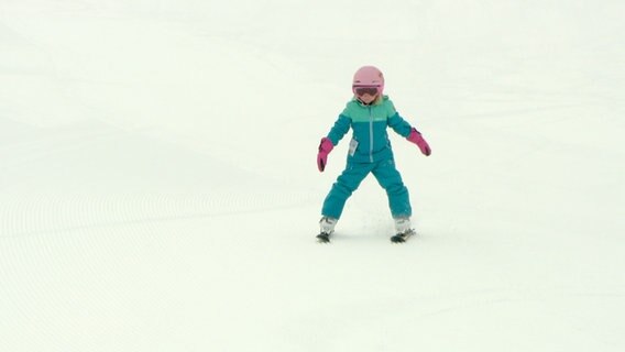 Ein Kind fährt auf Skiern einen  Berg hinunter. © NDR 