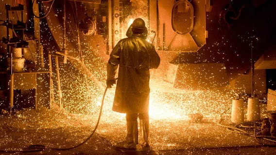 Ein Mitarbeiter der Salzgitter AG in Schutzkleidung arbeitet an einer Stahlpfanne. © picture alliance / Julian Stratenschulte/dpa Foto: Julian Stratenschulte