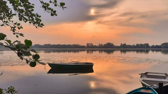 Oranger Sonnenaufgang am Seeburger See. Ein Boot liegt auf dem Wasser © NDR Foto: Christian Würzbach