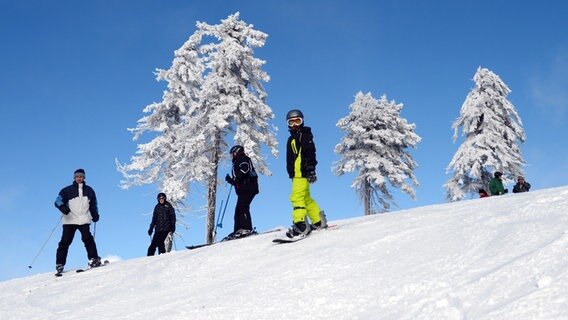 Ski- und Snowboardfahrer fahren auf dem Wurmberg in Braunlage. © dpa Foto: Julian Stratenschulte