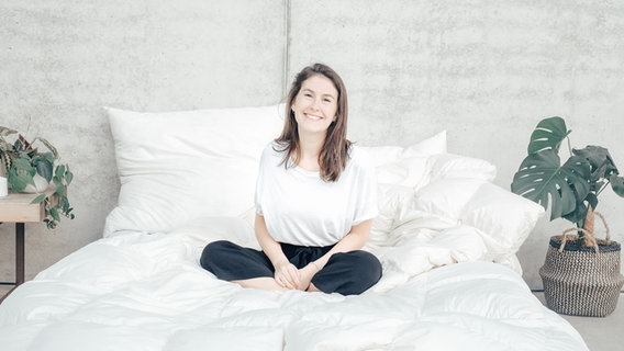 Unternehmerin Frederike Albers sitzt zwischen recycelten Bettwaren. © snuuz Foto: Slvie Tittel