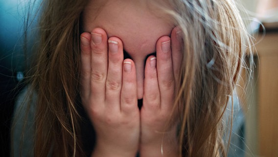 Ein junges Mädchen hält sich die Hände vor ihr Gesicht. © dpa-Bildfunk Foto: Nicolas Armer