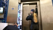Servicetechnikerin Julia Wolters repariert mit einem Kollegen einen Fahrstuhl. © NDR 