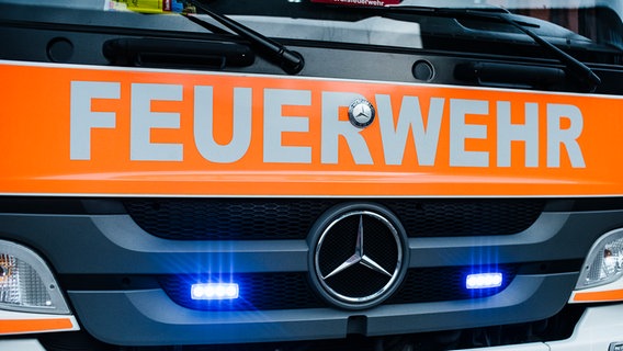 Auf der Front eines Fahrzeugs steht der Schriftzug Feuerwehr. © NDR Foto: Julius Matuschik