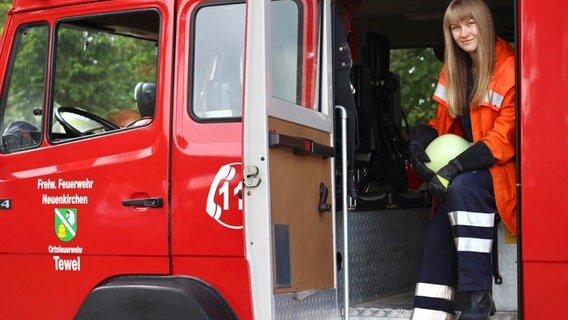 Märit Heuer in Feuerwehr-Montur in einem Einsatzfahrzeug der Feuerwehr. © NDR 