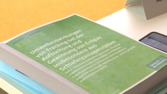Ein Buch mit einer Studie der Umweltauswirkungen zum Fracking liegt auf einem Tisch. © NDR 