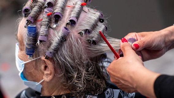 Einer Frau werden in einem Friseursalon die Haare frisiert. © dpa-Bildfunk Foto: Jens Büttner