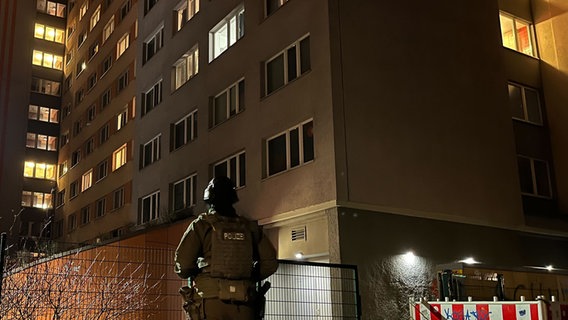 Ein Polizist steht vor einem Hochhaus in Berlin-Friedrichshain. © dpa Foto: Dominik Totaro