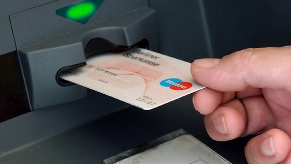 Ein Kunde steckt seine EC-Karte in den Geldautomaten einer Bank. © dpa 