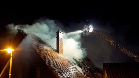 Ein Feuerwehrmann auf einer Drehleiter löscht ein brennendes Haus in Algesdorf. © Hannover Reporter 