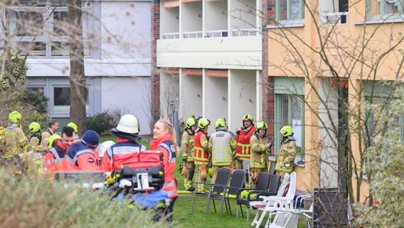 Einsatzkräfte der Feuerwehr Hannover und Rettungsdiensten stehen bei einem Brandeinsatz in einem Seniorenwohnheim. © Julian Stratenschulte/dpa Foto: Julian Stratenschulte