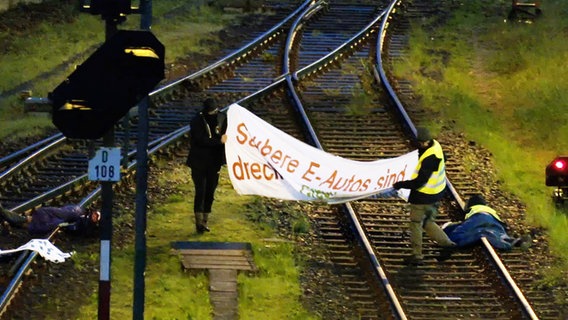 Aktivisten auf Bahngleisen blockieren einen Autozug von Mercedes in Bremen. © TeleNewsNetwork 
