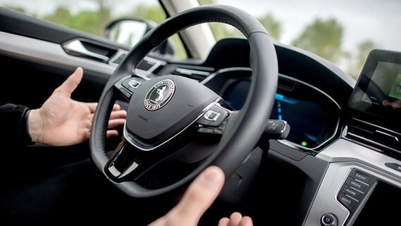 Ein Mann fährt in einem Auto mit dem von Continental entwickelten System "Cruising Chauffeur" und nimmt dabei die Hände vom Lenkrad.  Foto:  Hauke-Christian Dittrich