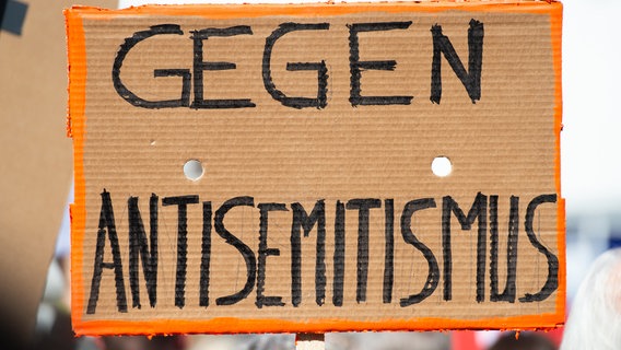 Bei einer Kundgebung eines Bündnisses gegen Antisemitismus wird ein Plakat mit der Aufschrift "Gegen Antisemitismus" in die Höhe gehalten. © picture alliance Foto: Christophe Gateau