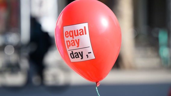 Ein Ballon mit der Aufschrift "Equal Pay Day" fliegt durch die Luft. © picture alliance/dpa | Julian Stratenschulte Foto: Julian Stratenschulte