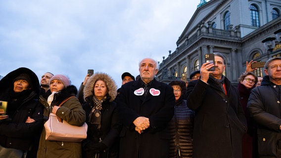 Menschen stehen in Hannover vor der Oper und gedenken der Erdbebenopfer. © dpa-bildfunk Foto: Michael Matthey
