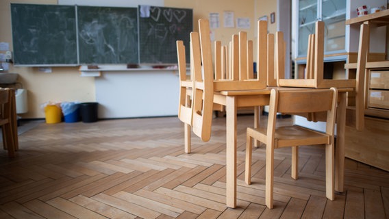 Stühle sind in einem leeren Klassenzimmer gestapelt. © picture alliance/dpa/Julian Stratenschulte Foto: Julian Stratenschulte