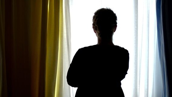 Eine junge Frau steht in einem Zimmer eines Frauenhauses. © dpa/picture alliance Foto: Peter Steffen