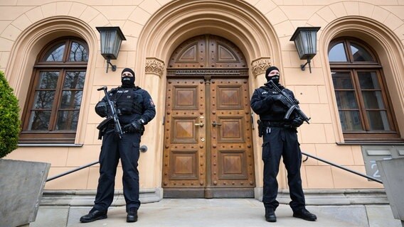 Bewaffnete Polizeibeamte stehen vor dem Gebäude des Oberlandesgerichts in Celle. © picture alliance/dpa Foto: Julian Stratenschulte
