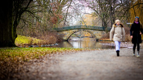 Eine Brücke im Georgengarten an den Herrenhäuser Gärten führt bei trübem Wetter über einen Teich. © dpa-Bildfunk Foto: Moritz Frankenberg/dpa