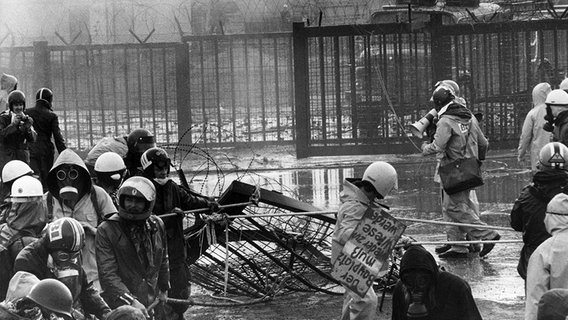 Das schwarz/weiß Foto zeigt Demonstranten und Polizisten bei einer Straßenschlacht auf dem Gelände des Atomkraftwerks Grohnde. © picture-alliance / Dieter Klar Foto: Dieter Klar