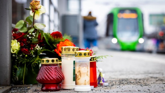 Blumen und Kerzen liegen an einem Bahnsteig der Stadtbahnhaltestelle «Fiedelerstraße» im Stadtteil Döhren. © dpa-Bildfunk Foto: Moritz Frankenberg/dpa