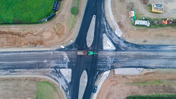 Auf einer Straßenkreuzung der sich im Bau befindlichen B3-Ortsumgehung bei Hemmingen ist ein Traktorgespann aus der Luft zu sehen. © dpa - Bildfunk Foto: Julian Stratenschulte