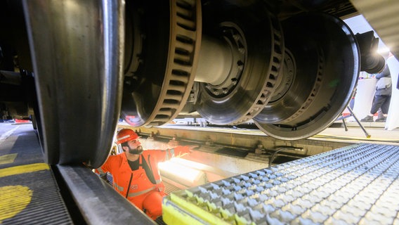 Hannover: Ein Mitarbeiter der Deutschen Bahn sitzt im Werk Hannover unter einem ICE T. © dpa-Bildfunk Foto: Julian Stratenschulte