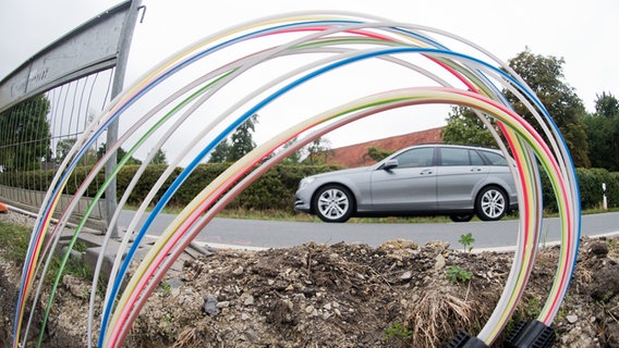 Leerrohre für Glasfaserleitungen für schnelles Internet liegen an einer Landstraße . © dpa-Bildfunk Foto: Julian Stratenschulte