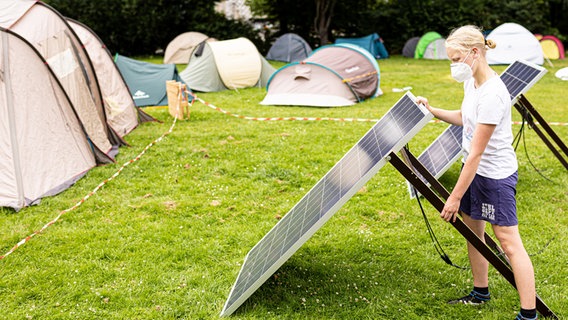 Ein Klima-Aktivist installiert eine Solarplatte in einem Klimacamp. © dpa-Bildfunk Foto: Moritz Frankenberg