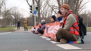 Klimaaktivisten blockieren eine Straße am Deisterkreisel in Hannover. © TeleNewsNetwork 