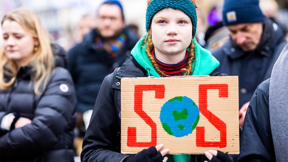 Der Schriftzug "SOS" ist auf einem Protestplakat bei einer Kundgebung zum Klimastreik von Fridays for Future in Hannover zu lesen © dpa 