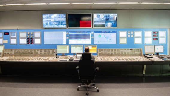Ein Mitarbeiter sitzt vor zahlreichen Bildschirmen im Kontrollraum des Kohlekraftwerk Mehrum. © dpa-Bildfunk Foto: Julian Stratenschulte