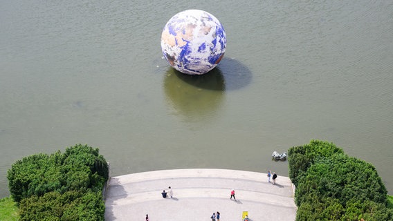 Das Kunstwerk "Floating Earth" des Künstlers Luke Jerram schwimmt auf dem Maschteich als Teil der Kunstfestspiele Herrenhausen. © dpa Foto: Julian Stratenschulte