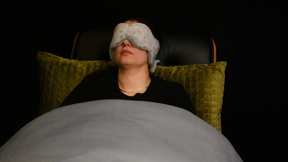 Eine Frau liegt mit einer Schlafmaske auf einem Sessel. © Deutsche Messe AG 