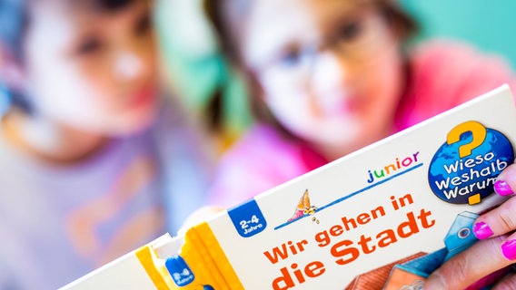 Zwei Kinder nehmen am Deutschunterricht in der Comeniusschule in Hannover teil und blicken dabei in ein Buch. © dpa-Bildfunk Foto: Moritz Frankenberg