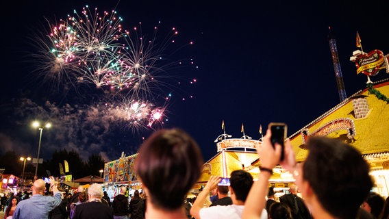 Besucher vom Schützenfest schauen sich auf dem Schützenplatz das Feuerwerk zur Eröffnung des Festes an. © dpa Foto: Michael Matthey