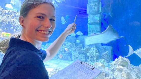 Meeresbiologin Lisa Winkelgrund lächelt in die Kamera vor einem Aquarium. © NDR Foto: Niels Kristoph