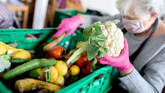 Eine ehrenamtliche Mitarbeiterin der „Hannöverschen Tafel“ bereitet die Ausgabe der Lebensmittel in einer kirchlichen Einrichtung am Mühlenberger Markt vor. © dpa-Bildfunk Foto: Hauke-Christian Dittrich