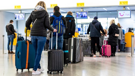Fluggäste mit dem Reiseziel Mallorca stehen im Flughafen Hannover-Langenhagen am Check-in. © dpa-Bildfunk Foto: Moritz Frankenberg