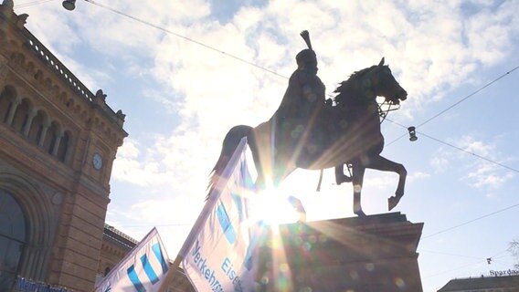 Das Ernst-August-Denkmal in Hannover. Davor eine Fahne (Warnstreik-Demo). © TNN 