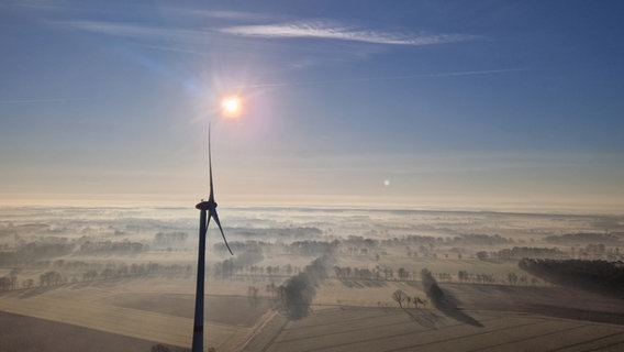 Eine Luftaufnahme zeigt ein Windrad in einer winterlichen Landschaft. © NDR Foto: Ronny Maler